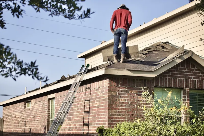 Professional roofer working on a residential roof in Oak Island Junction